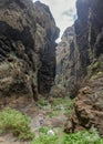 Rocks in the Masca gorge, Tenerife, showing solidified volcanic lava flow layers and arch formation. The ravine or barranco leads