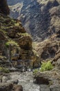 Rocks in the Masca gorge, Tenerife, showing solidified volcanic lava flow layers and arch formation. The ravine or barranco leads