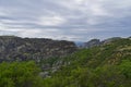 rocks, mountains, gray-white fluffy clouds, green vegetation, in Greece Royalty Free Stock Photo