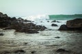 Rocks in an ocean bay with waves in the background Royalty Free Stock Photo