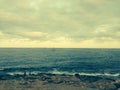 Rocks and ocean scene in Spain with sailboat in di