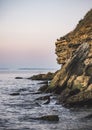 Rocks and pieces of stones, a cliff and a steep coast of the Black Sea against which waves break Royalty Free Stock Photo