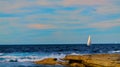 Rocks, sailing boats and ocean at sunset Royalty Free Stock Photo