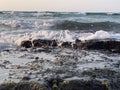 Rocks in the sea with a foaming wave