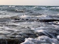 Rocks in the sea with a foaming wave