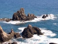 Rocks on the shoreline. Slightly undulating seawater hits the rocks