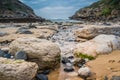 Rocks and small stream of water to go against the sea, in Praia da Samarra, flanked by mountains, Sintra - Lisbon, Portugal Royalty Free Stock Photo