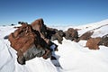 Rocks in snow against a clear blue sky near Elbrus