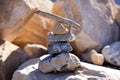 Rocks are stacked in a pyramid shape with a piece of driftwood on top. Royalty Free Stock Photo