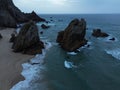 rocks sticking out of the sea and a beach on the shore