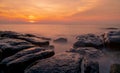 Rocks on stone beach at sunset. Beautiful beach sunset sky. Twilight sea and sky. Tropical sea at dusk. Dramatic sky and clouds.