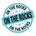 ON THE ROCKS text written on blue-black round stamp sign