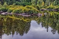 Rocks, trees and bushes in complete reflection - current river, , Thunder Bay, ON, Canada Royalty Free Stock Photo