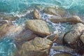 Rocks in the tropical deep blue sea with gentle waves flowing th Royalty Free Stock Photo