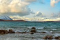 Rocks in turquoise water, waves in Lake Tekapo, background is Mount Cook Mountains. On a beautiful cloudy day on the South Island Royalty Free Stock Photo