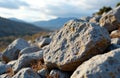 Rough rocks scattered across a natural landscape with mountains in the Royalty Free Stock Photo