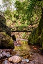 Rocks and water of Barroca de DegraÃÂ­nhos in lowlight with wooden foot bridge in Fraga da Pena, Arganil PORTUGAL