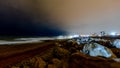 Rocks, waves, sand and clouds by night Royalty Free Stock Photo