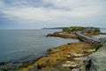 The rocky beach with e old bridge to the island in Botany bay in Sydney Royalty Free Stock Photo