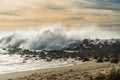 Rocky beach sunset and stormy ocean waves splashing high into the air against rocks at Morro Bay, CA Royalty Free Stock Photo