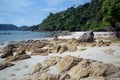 Rocky beach with a view of rock and sea. Rocky cliffs and sea waves on sandy beach.