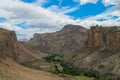 Rocky canyon small river and green oasis valley