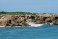 Rocky cliff, Blue ocean, Crashing waves, clear sky Royalty Free Stock Photo