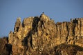 Rocky cliff face at sunset against a blue sky.