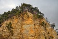 A rocky cliff with a layered structure of sedimentary rocks Royalty Free Stock Photo