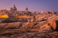 Rocky coast of Malta and the architecture of Valletta city at dawn Royalty Free Stock Photo