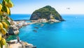 Rocky coast of Sant`Angelo, giant green rock in blue sea near Ischia Island, Italy. Sant`Angelo is small village within comune o