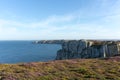 Rocky coastal cliffs with lilac heath on the Brittany coast Royalty Free Stock Photo