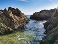 Rocky coastal landscape scene at shore of ocean. Waves beat the sea foam on the sand on the beach. Tropical beach at sunset - Royalty Free Stock Photo