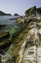 Rocky coastline with clear blue sea water and sky at sunny day Royalty Free Stock Photo