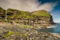 Rocky coastline with cliffs and waterfalls at village Mikladalur, Kalsoy island, Faroe Islands