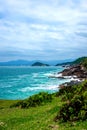 rocky coastline with turquoise-green water, green slopes and an absolutely blue sky Royalty Free Stock Photo