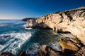 Rocky cove and ocean wave crashing into an eroded arch Royalty Free Stock Photo