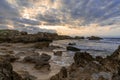 Rocky cove and sandy beach under an expressive sunset sky on the rugged west coast of Sardinia Royalty Free Stock Photo