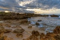 Rocky cove and sandy beach under an expressive sunset sky on the rugged west coast of Sardinia Royalty Free Stock Photo