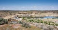 Rocky desert lake shore with grass and blue sky Royalty Free Stock Photo