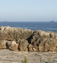 Rocky embankment at a cave A mouth of a devil Portugal (Boca do Inferno) with the ships in background