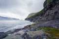 Rocky Faroese shore on a cloudy day. Cliffs of Kalsoy island. Late cloudy morning in the wild fjords of Faroe Islands near