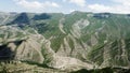 Rocky green mountains on cloudy sky background, aerial view. Action. Mountain range covered by greenery, New Zealand. Royalty Free Stock Photo