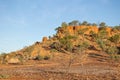 A rocky outcrop hill with sparse trees in outback country, Australia. Royalty Free Stock Photo