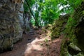 Rocky landscape, trail between slopes of moss-covered rock formations