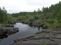 A rocky landscape with trees and rocks in the foreground. Suna River, Poor Porog Waterfall, Girvas, Republic of Karelia