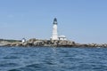 Rocky Ledge with Boston Light in the Harbor Royalty Free Stock Photo