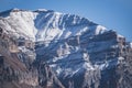 Rocky mountain with layered sharp slopes and snow on them and cliffs made of stones Royalty Free Stock Photo