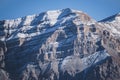 Rocky mountain with layered sharp slopes and snow on them and cliffs made of stones Royalty Free Stock Photo