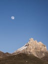 Rocky mountain peaks with the remains of snow against the background of a blue morning sky with a saturated moon Royalty Free Stock Photo